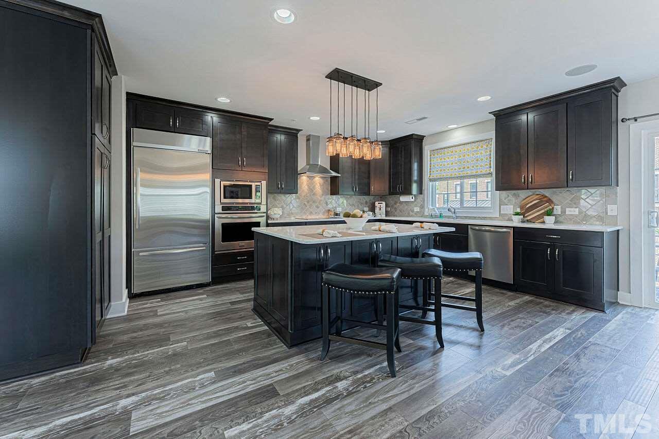 511 North Person Street, Unit 207 Raleigh, NC 27604 - Photo 6 of 17 Kitchen with custom cabinetry, SS high end appliances including built in wine cooler. Quartz countertops and surround sound.