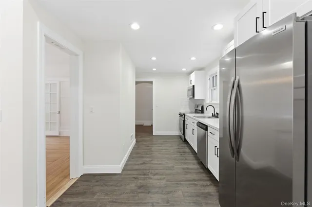 a bathroom with a sink a refrigerator and a mirror