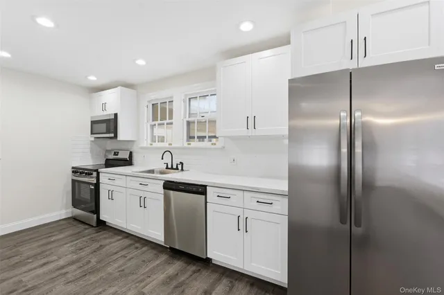 a kitchen with white cabinets and stainless steel appliances
