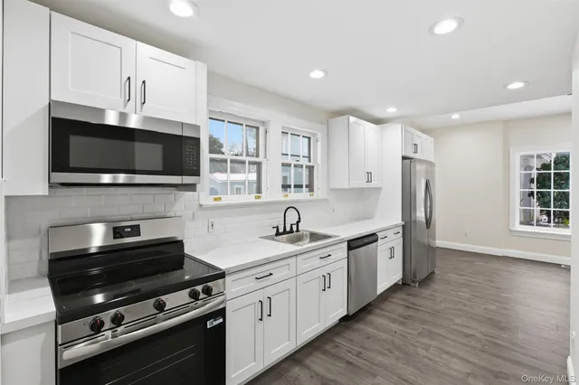 a kitchen with stainless steel appliances a stove microwave and sink