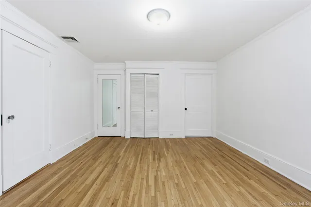 a view of a room with wooden floor and white walls