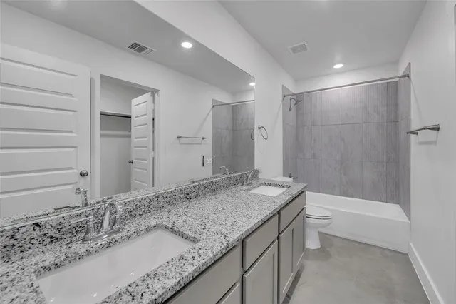 a bathroom with a granite countertop sink and mirror with bathtub