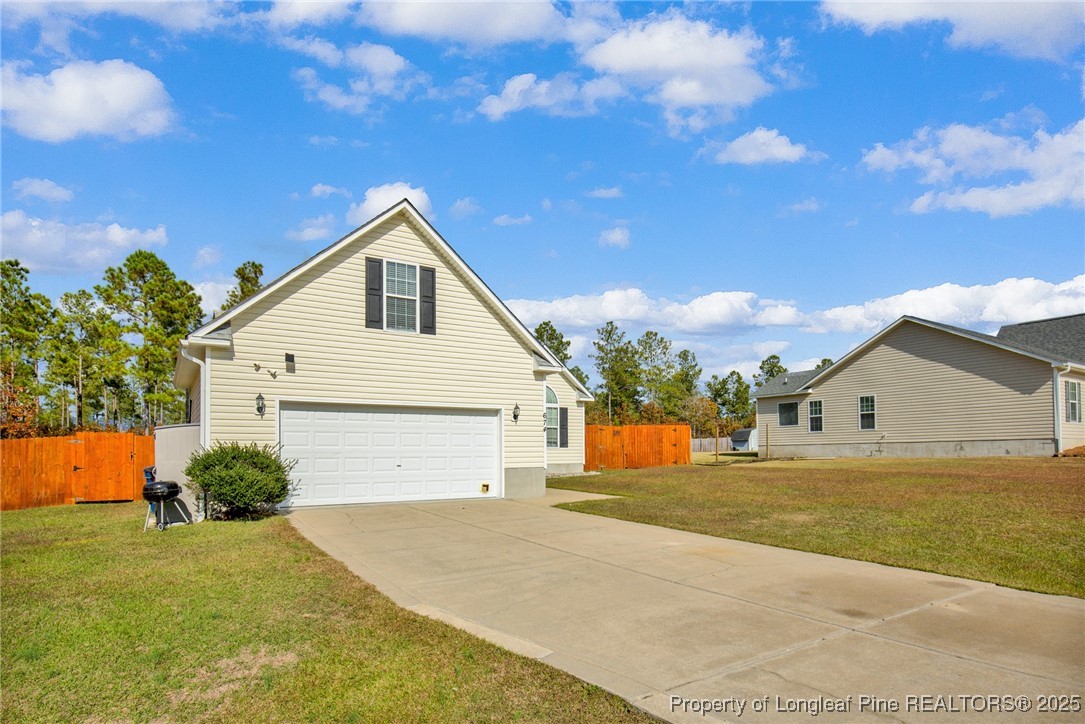 674 Copper Creek Drive Raeford, NC 28376 - Photo 2 of 20 a front view of a house with a yard and garage