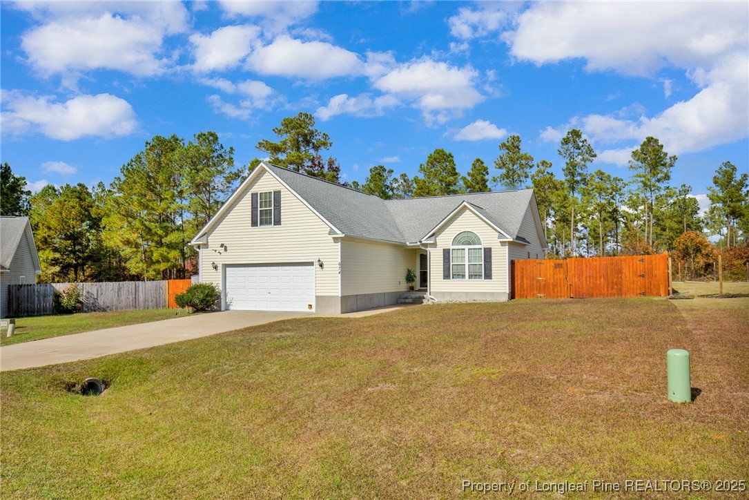 674 Copper Creek Drive Raeford, NC 28376 - Photo 3 of 20 a front view of a house with a yard and garage