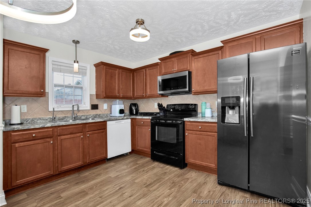 674 Copper Creek Drive Raeford, NC 28376 - Photo 8 of 20 a kitchen with stainless steel appliances granite countertop a refrigerator a stove top oven a sink and dishwasher