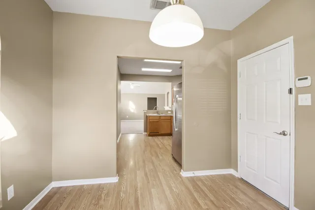 a view of a hallway with wooden floor and a bathroom