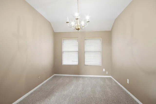 an empty room with windows and chandelier