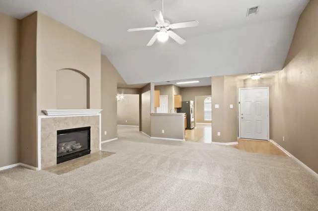 a view of a livingroom with a fireplace and chandelier fan