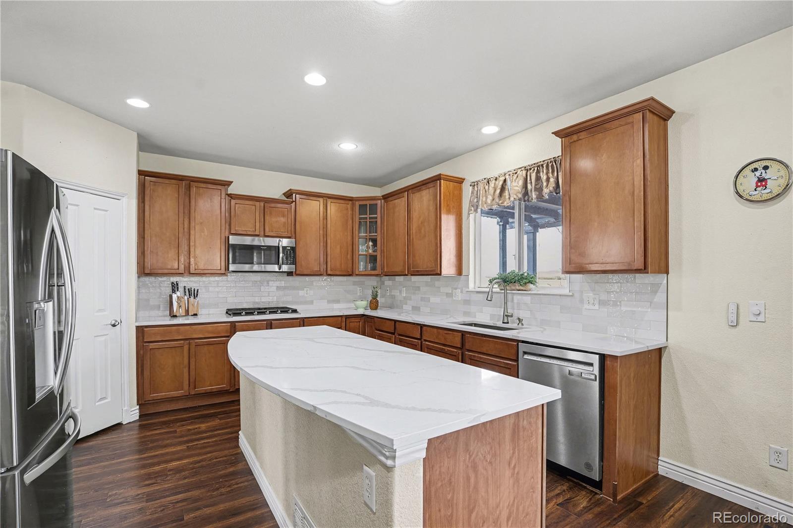10871 Chambers Way Commerce City, CO 80022 - Photo 14 of 50 a kitchen with stainless steel appliances granite countertop a sink stove microwave and refrigerator