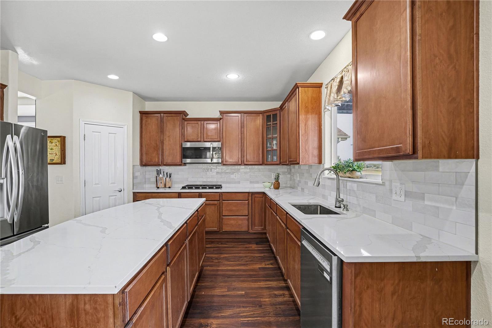 10871 Chambers Way Commerce City, CO 80022 - Photo 15 of 50 a kitchen with stainless steel appliances granite countertop a sink a stove a refrigerator a sink and dishwasher