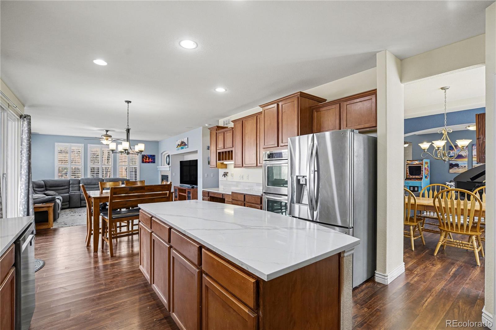 10871 Chambers Way Commerce City, CO 80022 - Photo 16 of 50 a kitchen with stainless steel appliances granite countertop a refrigerator a stove top oven a sink dishwasher a dining table and chairs with wooden floor