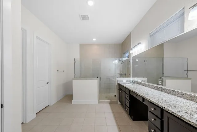 a spacious bedroom with a bed a couch and a flat screen tv