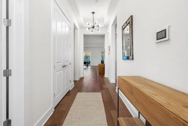 a view of a hallway with wooden floor and staircase