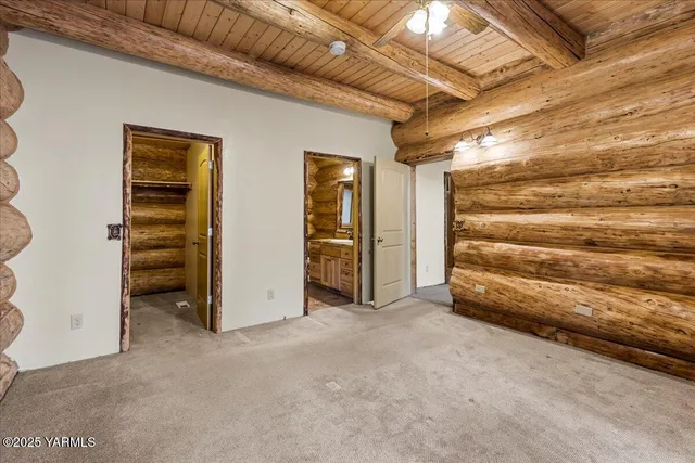 a view of an empty room with closet and a window