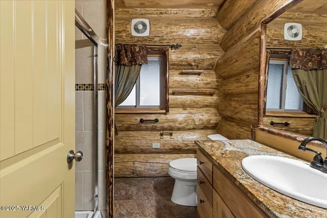 a bathroom with a granite countertop toilet sink and mirror