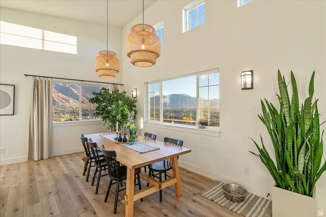 1800 Spring Oaks Drive Springville, UT 84663 - Photo 22 of 68 Dining area featuring light wood-style flooring, a towering ceiling, plenty of natural light, and a mountain view