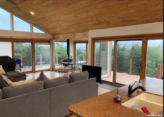a living room with furniture and floor to ceiling windows