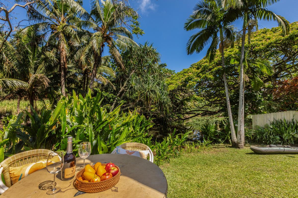 24 Off Moloaa Road Kilauea, HI 96754 - Photo 5 of 25 a backyard of a house with table and chairs potted plants