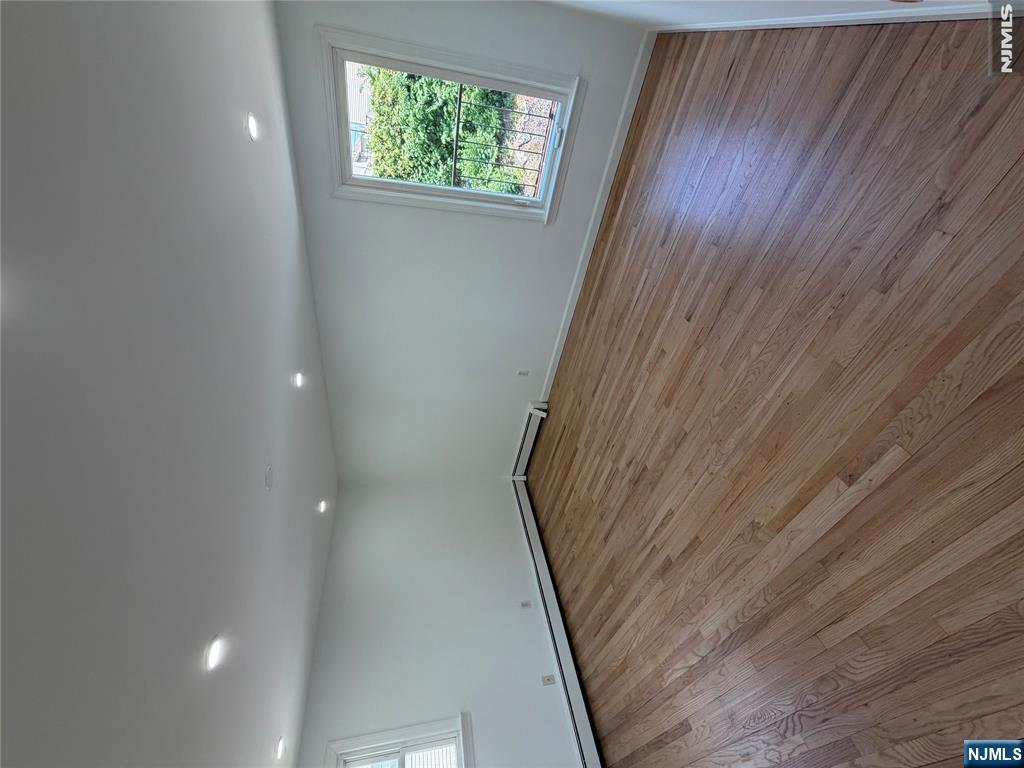 53 Devon Terrace, Unit 2 Kearny, NJ 07032 - Photo 8 of 15 an empty room with wooden floor and windows