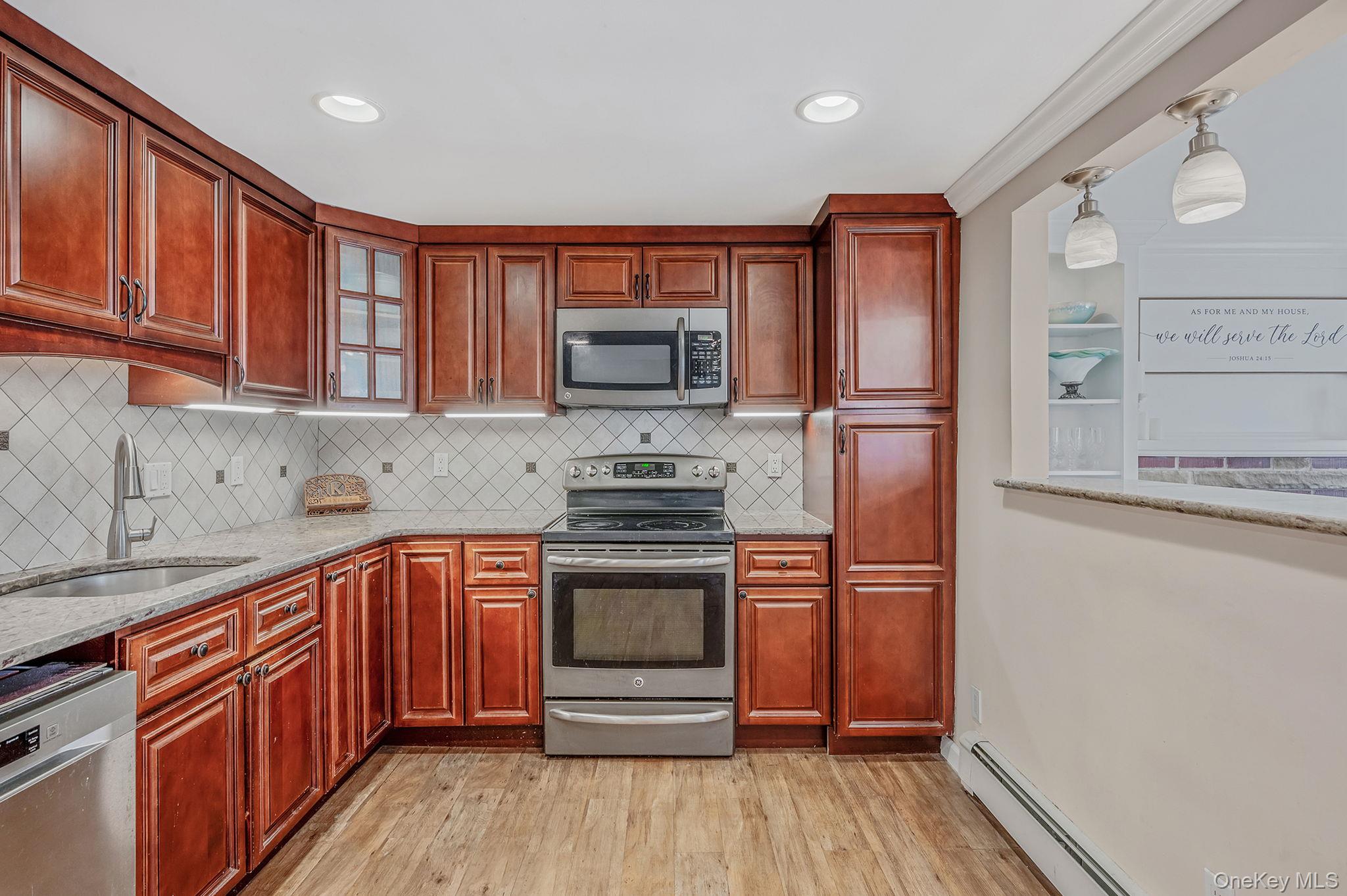 5 Valley Circle Miller Place, NY 11764 - Photo 13 of 38 a kitchen with stainless steel appliances granite countertop a refrigerator stove and sink