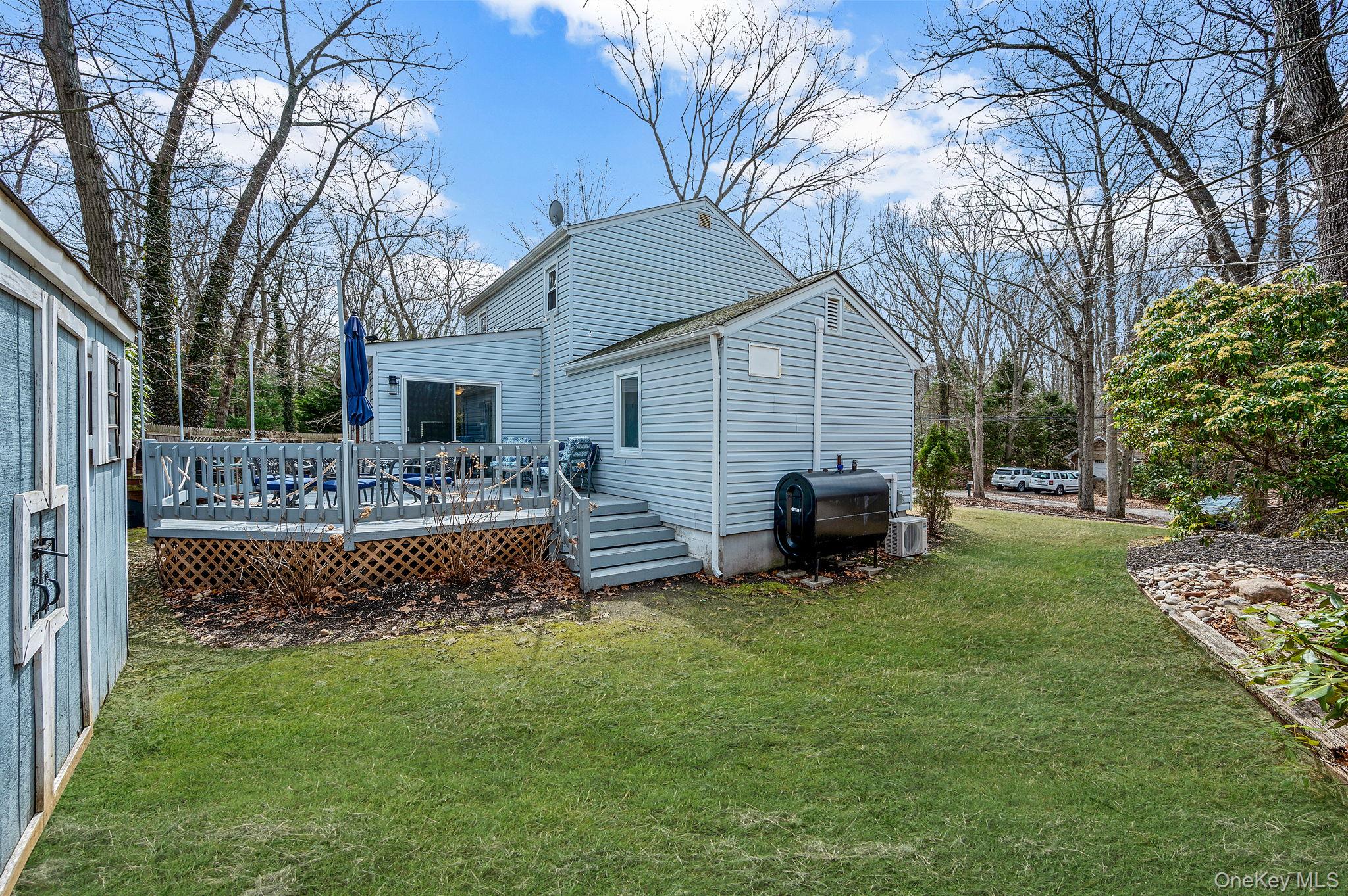 5 Valley Circle Miller Place, NY 11764 - Photo 30 of 38 a view of a house with a patio and a yard