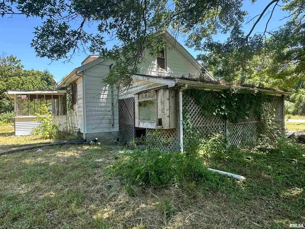 a backyard of a house with table and chairs under an umbrella