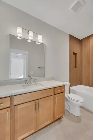 a bathroom with a toilet a sink and mirror