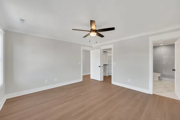 a view of a room with wooden floor and a ceiling fan