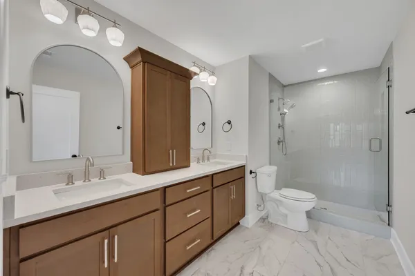 a bathroom with a double vanity sink mirror and toilet