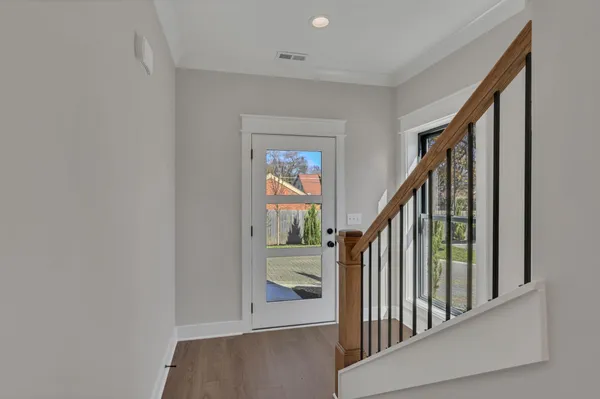 a view of staircase with railing and white walls