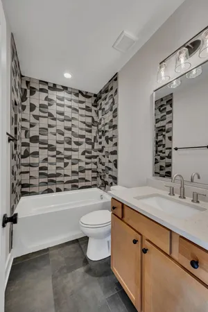 a bathroom with a granite countertop toilet a sink and a bathtub