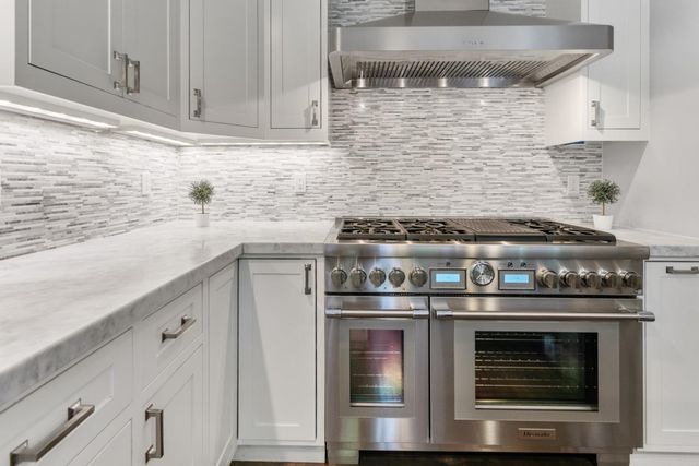 a stove top oven sitting inside of a kitchen