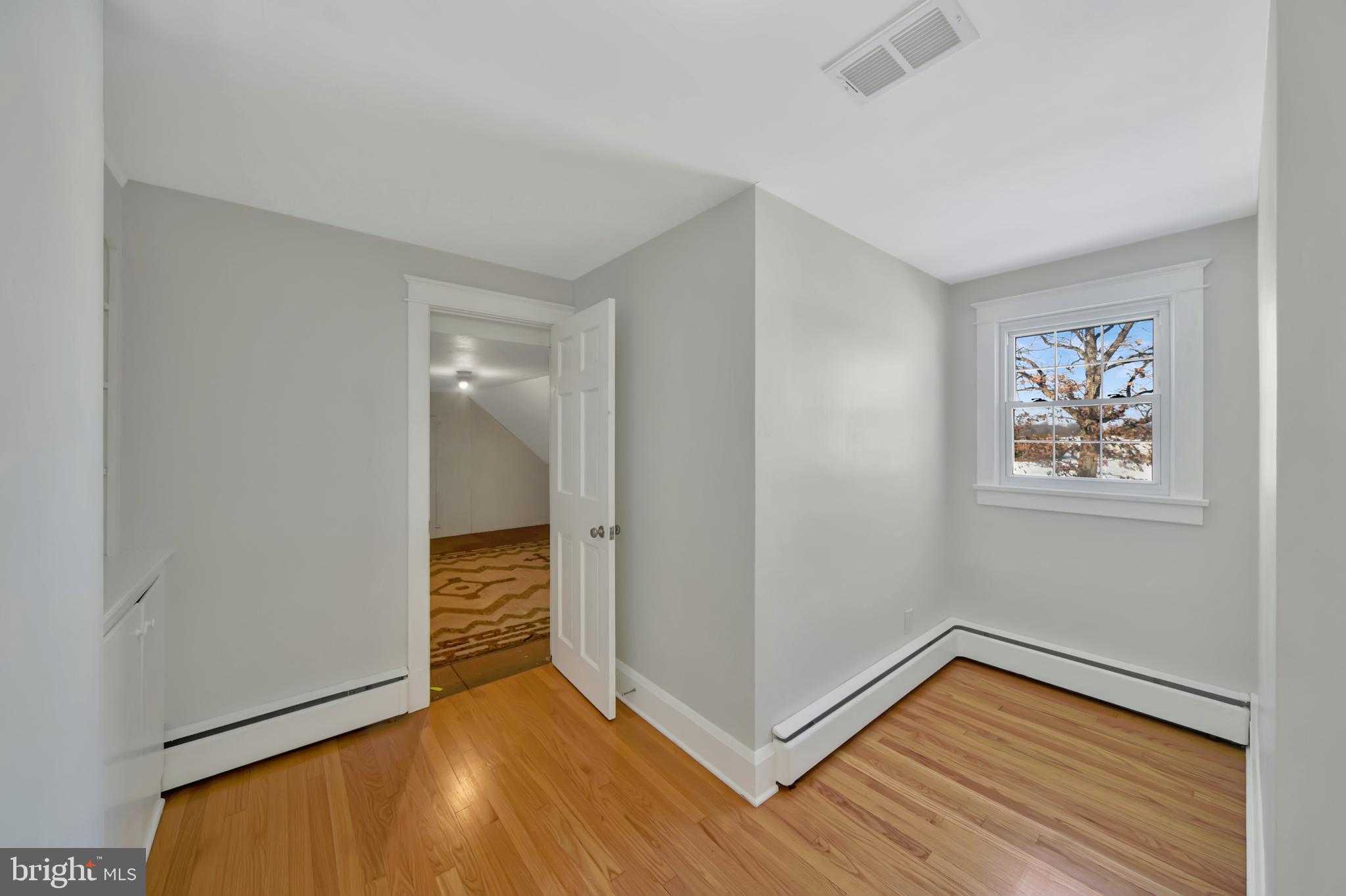 2675 Jolly Acres Road White Hall, MD 21161 - Photo 23 of 50 a view of an empty room with wooden floor and a window