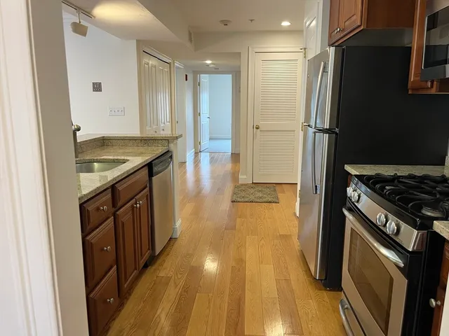 a kitchen with a sink and wooden floor
