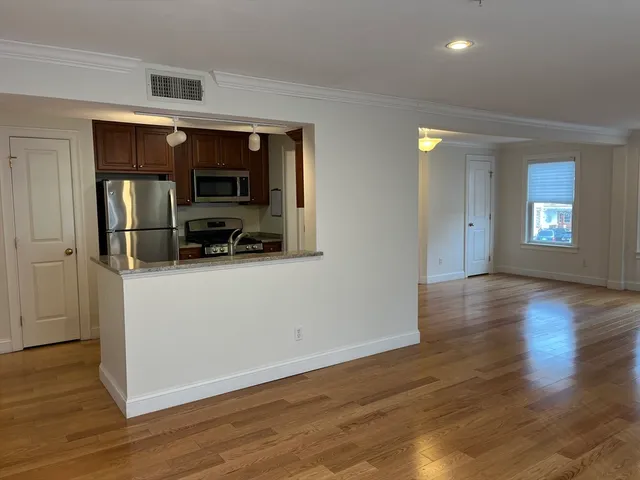 a view of a utility room with wooden floor and workspace