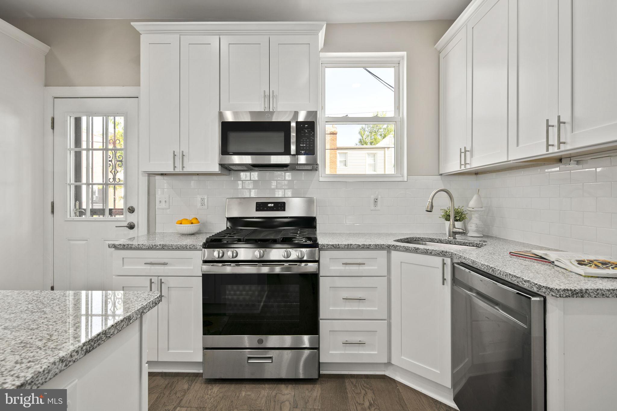 713 Rittenhouse Street Northwest Washington, DC 20011 - Photo 20 of 35 a kitchen with stainless steel appliances granite countertop a stove a sink and white cabinets
