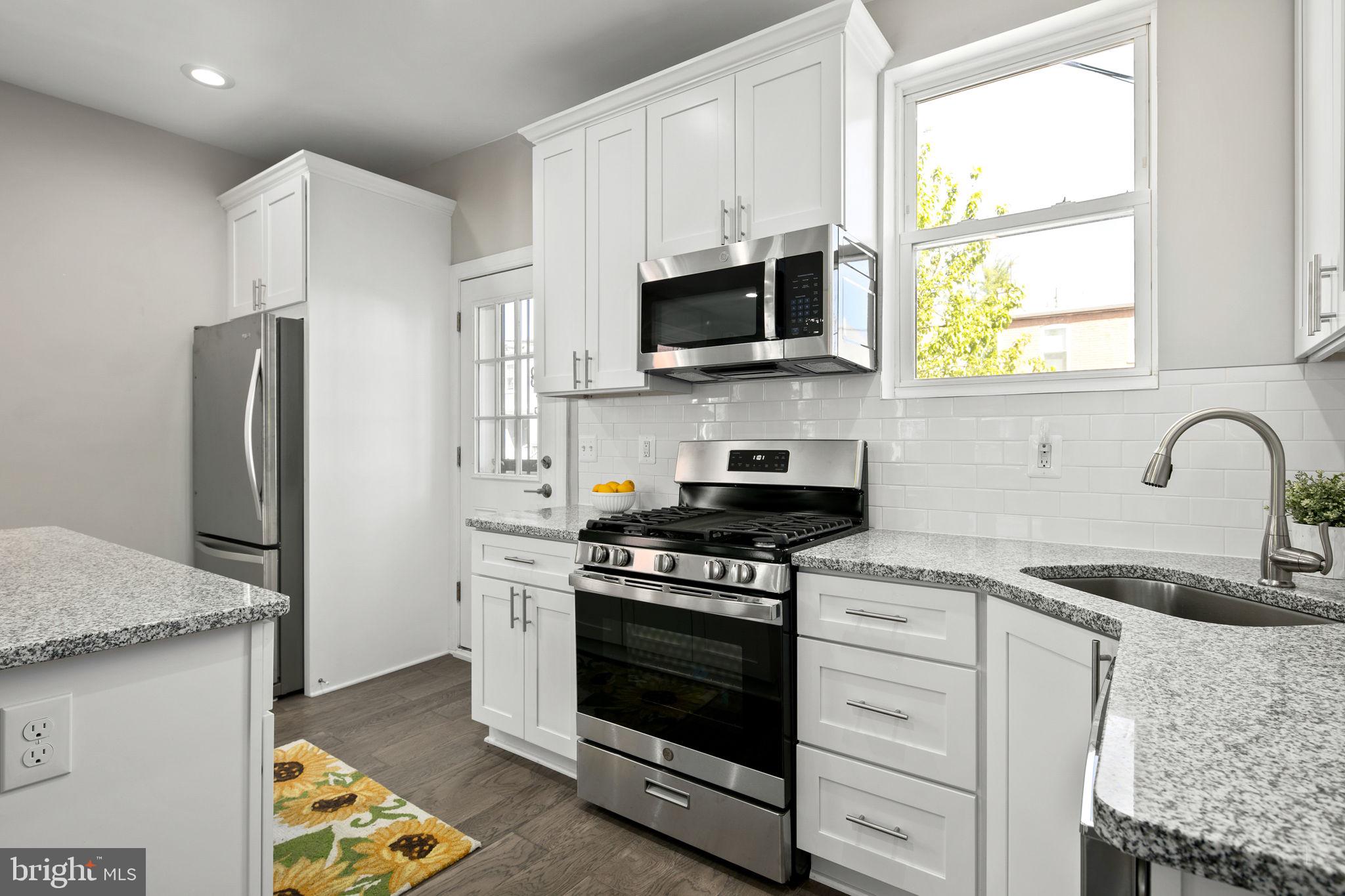 713 Rittenhouse Street Northwest Washington, DC 20011 - Photo 5 of 35 a kitchen with stainless steel appliances granite countertop grey cabinets a stove a sink and a refrigerator