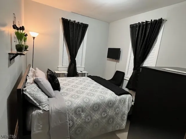 a bedroom with a bed a window and television