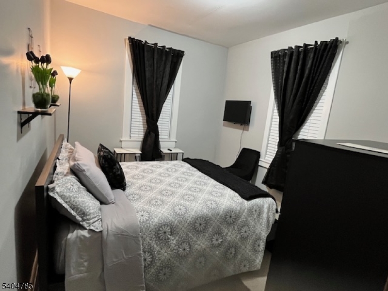 42 Harding Terrace Newark, NJ 07112 - Photo 5 of 7 a bedroom with a bed a window and television