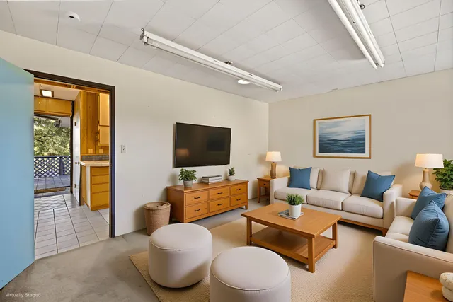 a living room with furniture a flat screen tv and a window