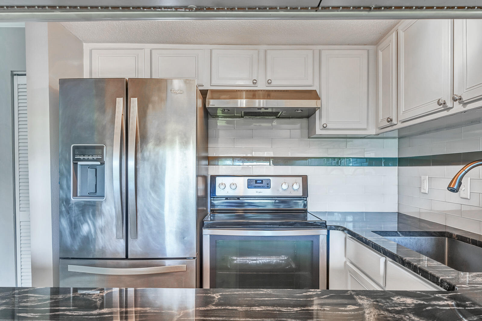 101 Old Ferry Road, Unit 5B Shalimar, FL 32579 - Photo 5 of 22 a kitchen with granite countertop a refrigerator and a sink
