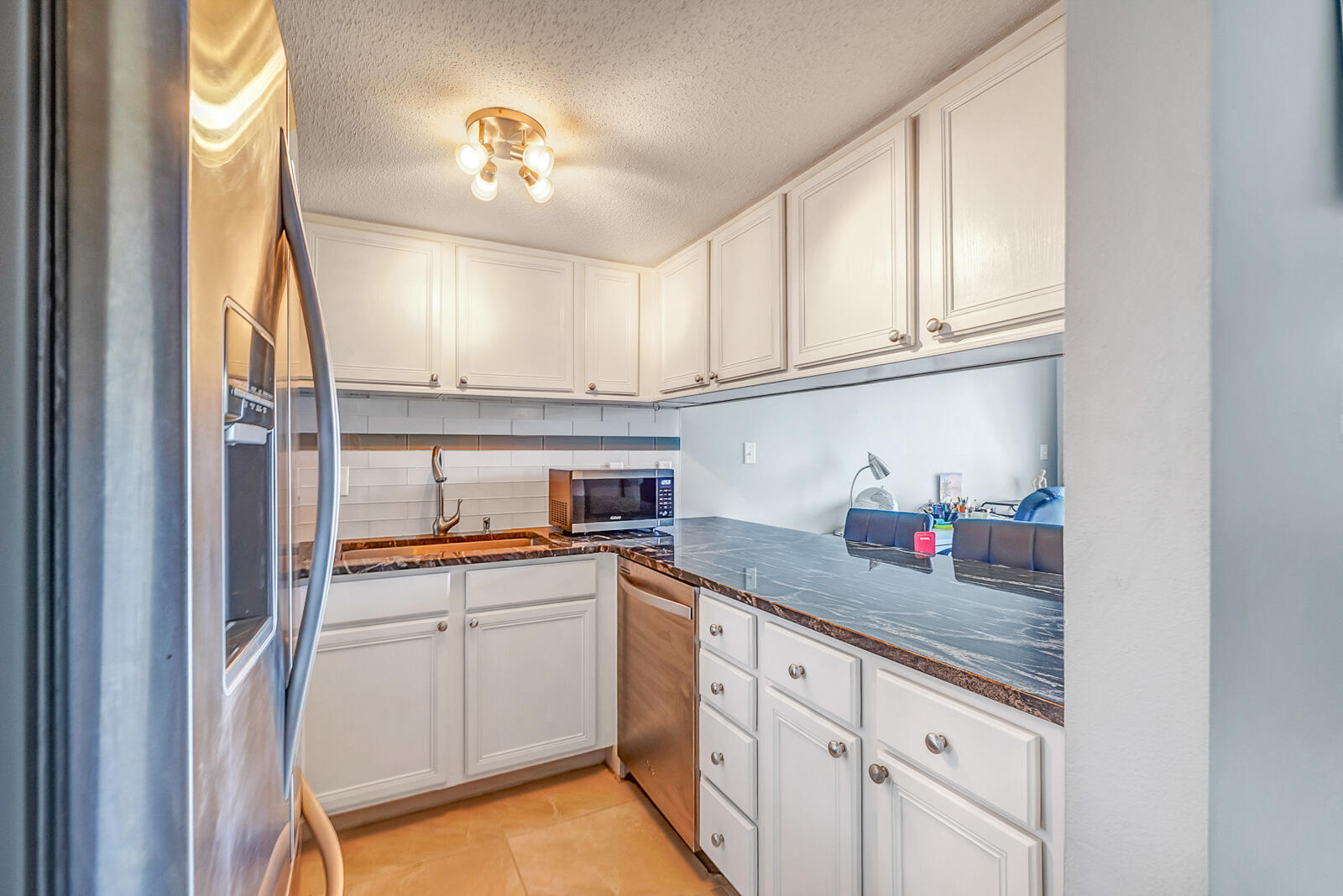 101 Old Ferry Road, Unit 5B Shalimar, FL 32579 - Photo 6 of 22 a kitchen with granite countertop white cabinets and white appliances