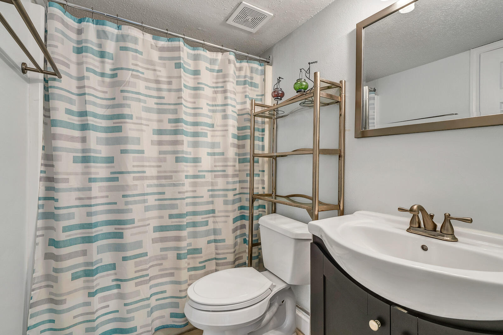 101 Old Ferry Road, Unit 5B Shalimar, FL 32579 - Photo 10 of 22 a bathroom with a sink a toilet and shower curtain
