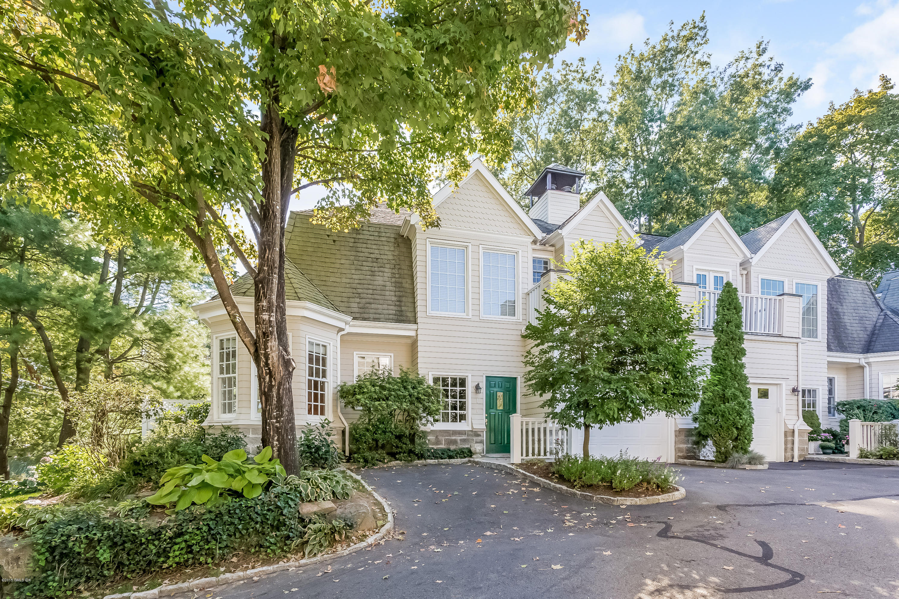 48 Spring Street, Unit 1 Greenwich, CT 06830 - Photo 1 of 18 a front view of a house with a garden