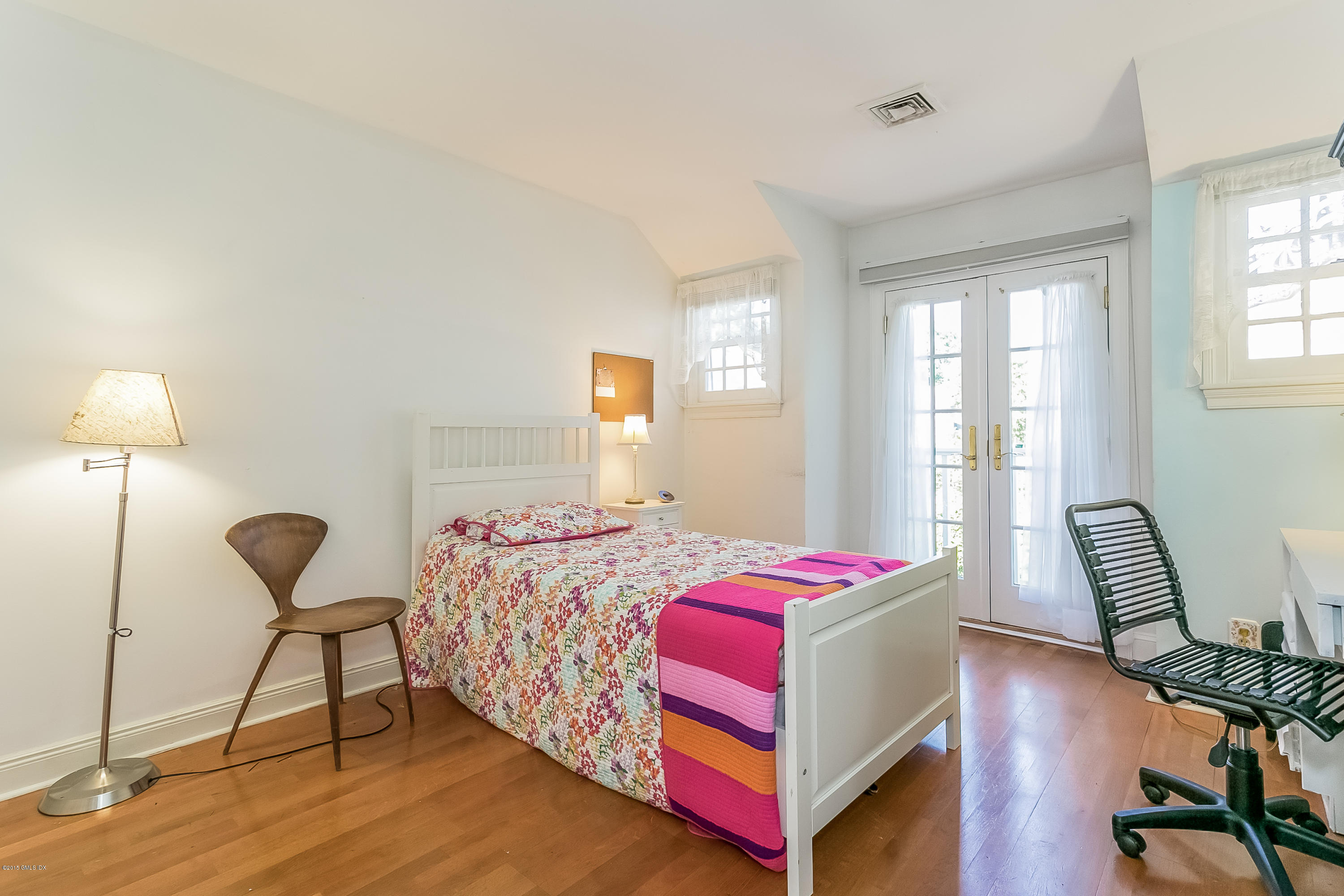 48 Spring Street, Unit 1 Greenwich, CT 06830 - Photo 12 of 18 a bedroom with a bed a chair and a large window