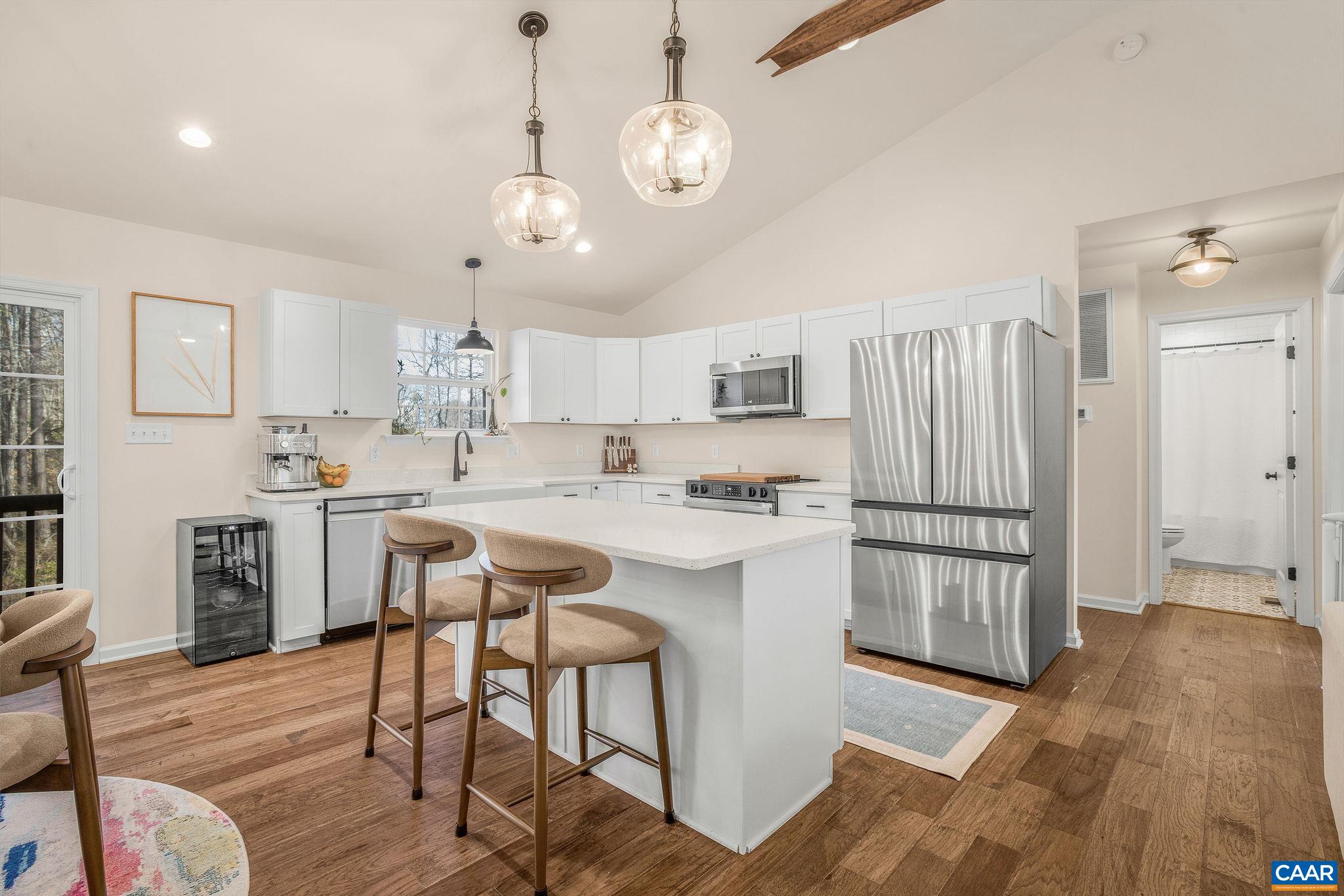 1229 Peach Grove Road Louisa, VA 23093 - Photo 11 of 47 a kitchen with stainless steel appliances granite countertop a refrigerator a sink dishwasher a stove and white countertops with wooden floor
