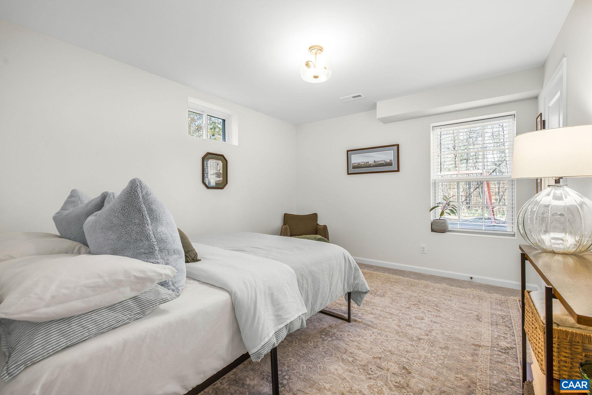 1229 Peach Grove Road Louisa, VA 23093 - Photo 35 of 47 a bedroom with a bed and a lamp on table