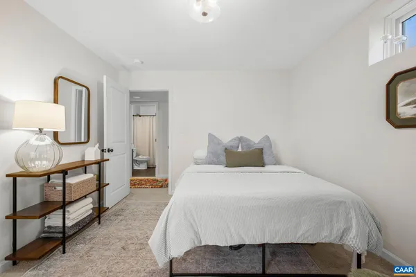 a bedroom with a bed a mirror and lamp