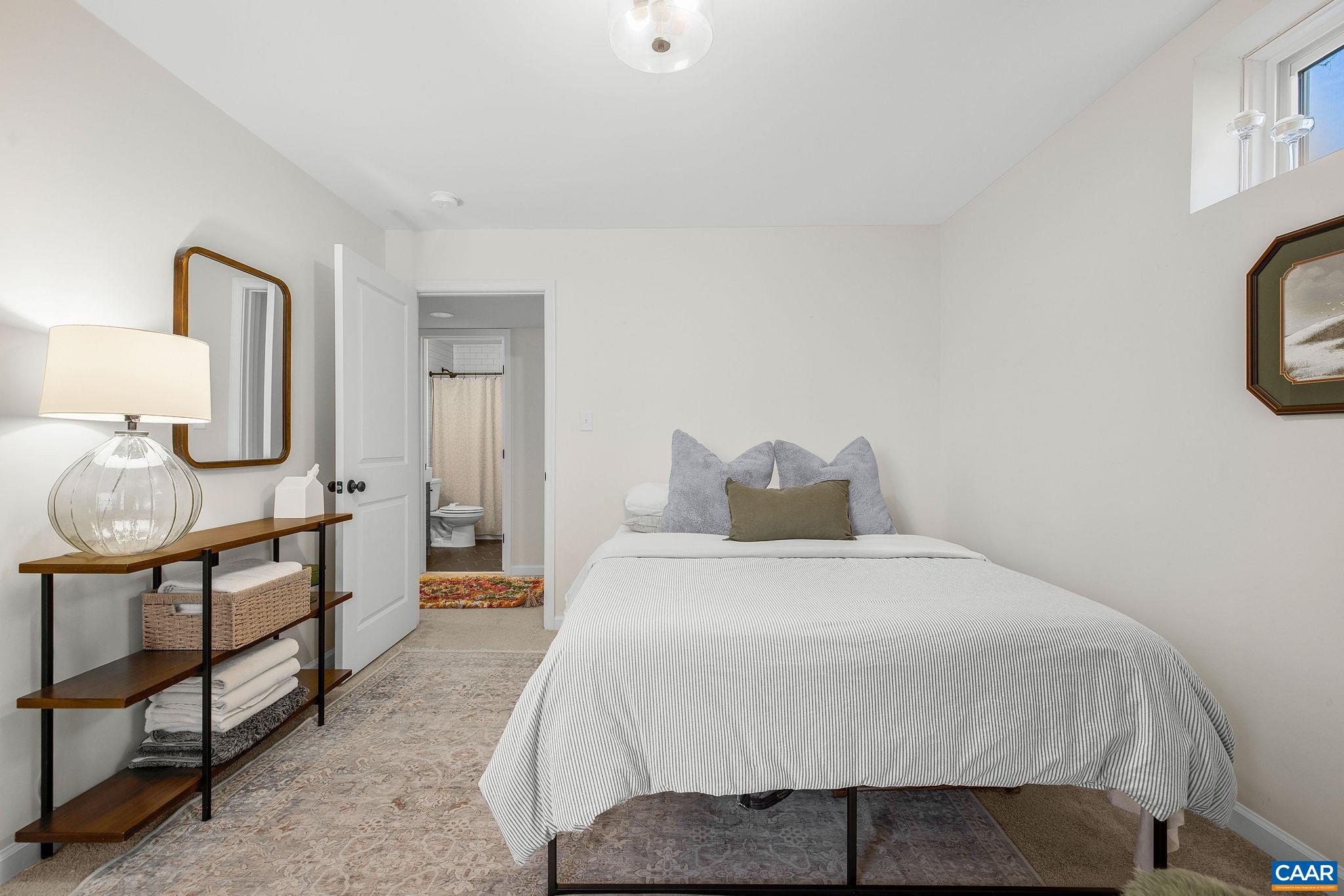 1229 Peach Grove Road Louisa, VA 23093 - Photo 36 of 47 a bedroom with a bed a mirror and lamp