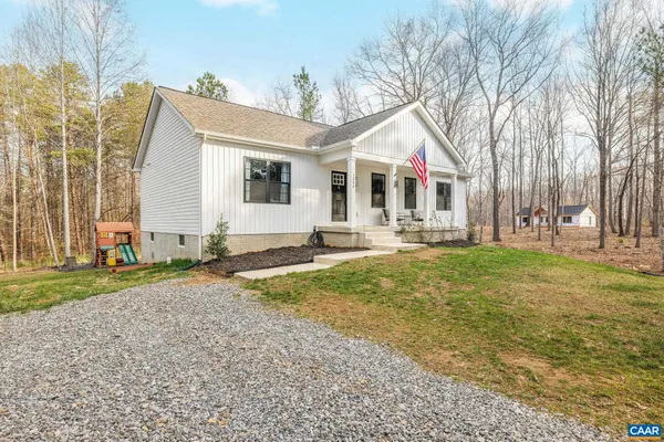 a front view of house with yard and trees around